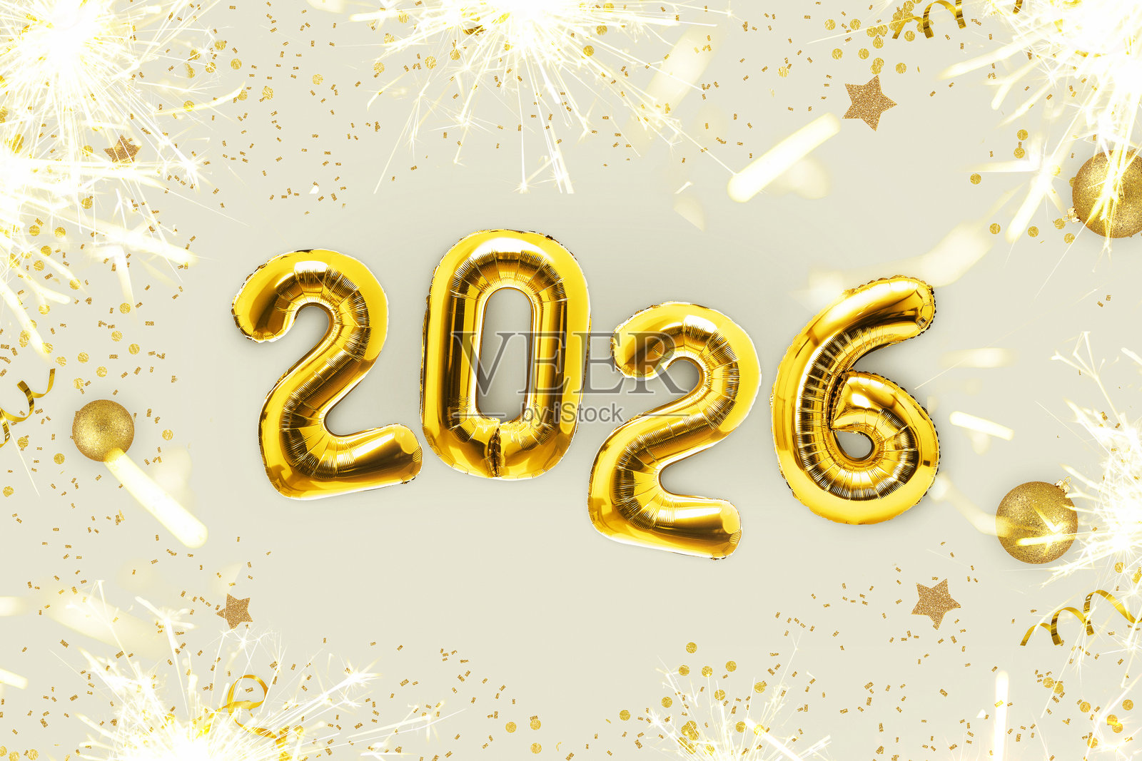 金色奢华气球,2026新年快乐,伴随金色火花和冷焰火,放置在米色桌子上,俯视角度。新年快乐2026和圣诞快乐贺卡照片摄影图片