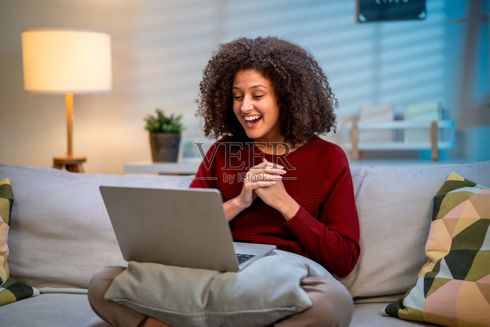 美丽的拉丁美女企业家晚上在家在线工作。这位美丽的女性自由职业者正在使用笔记本电脑与同事进行在线会议视频通话,进行远程工作。照片摄影图片