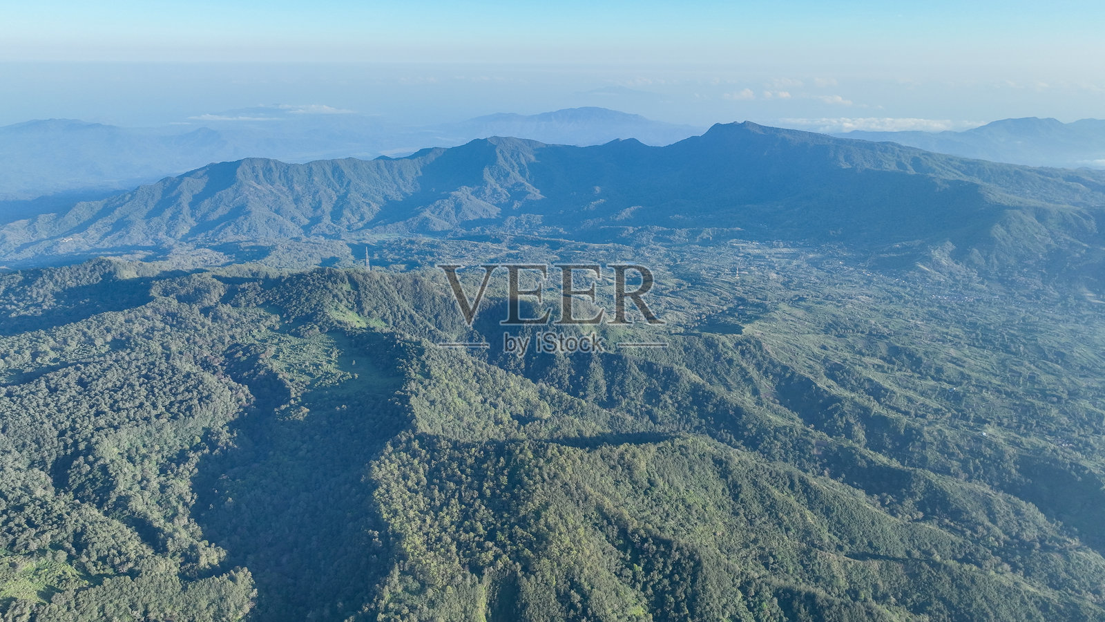 无数的山峰和山谷交织成一幅壮丽的绿色画卷,展现了印度尼西亚科利穆图火山附近未受破坏的荒野照片摄影图片