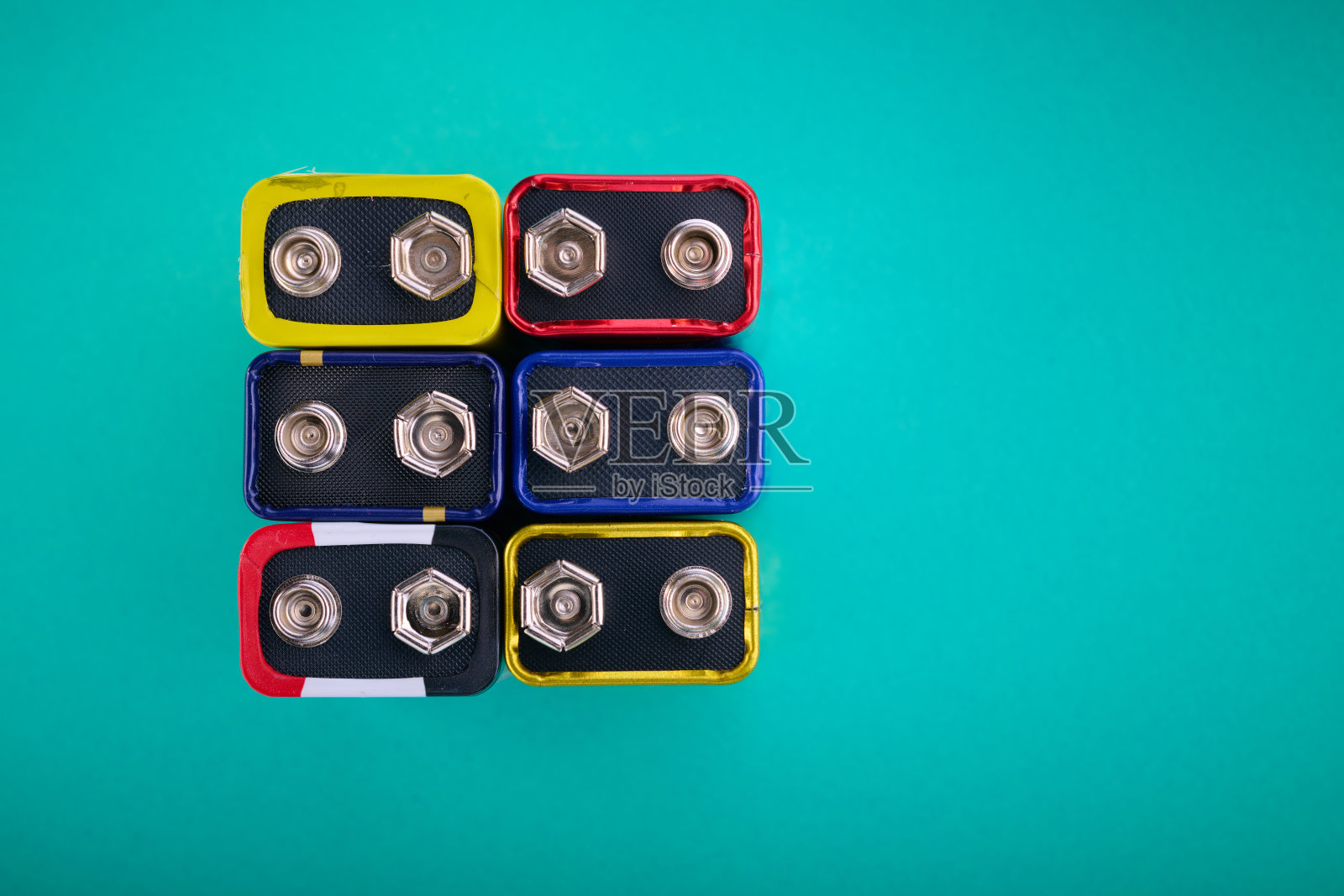 绿色桌面上矩形九伏电池的特写。照片摄影图片