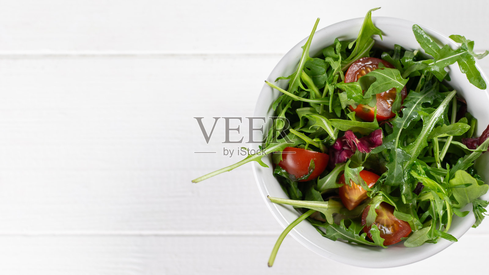 白色碗中新鲜芝麻菜和番茄沙拉,背景为乡村白色木板照片摄影图片