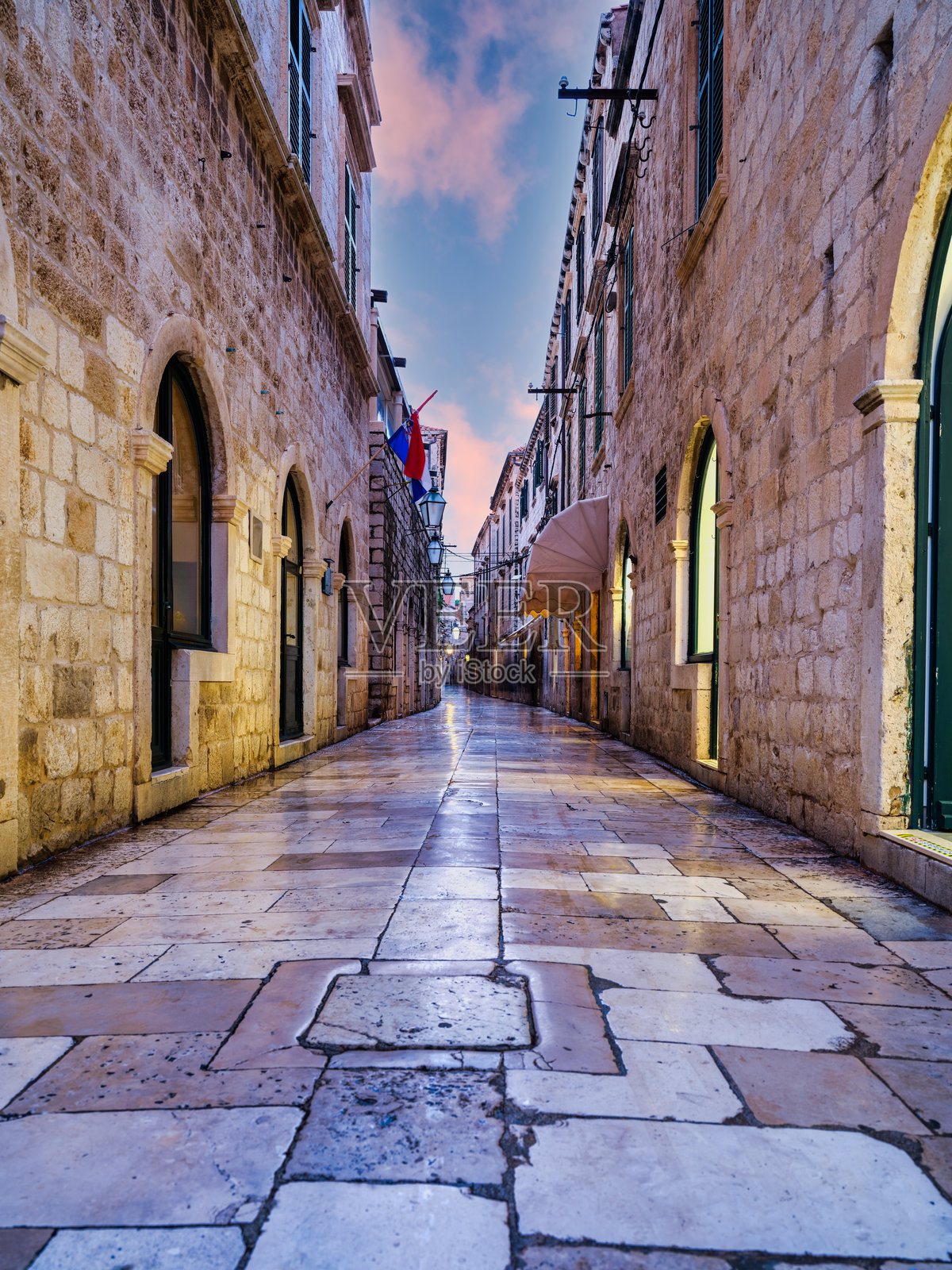 克罗地亚杜布罗夫尼克老城,低角度拍摄的灯光明亮狭窄街道及其倒影照片摄影图片