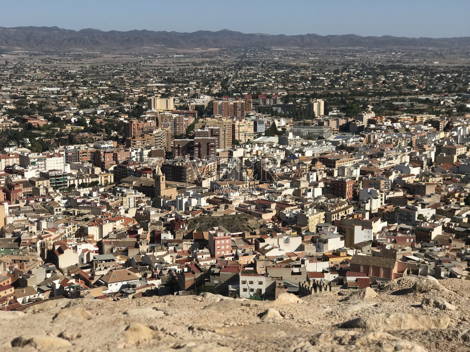 远眺城市景观,远方是连绵的山峦照片摄影图片