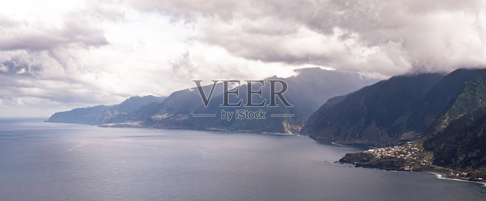 宁静的海边悬崖聚落与戏剧性的多云地平线照片摄影图片