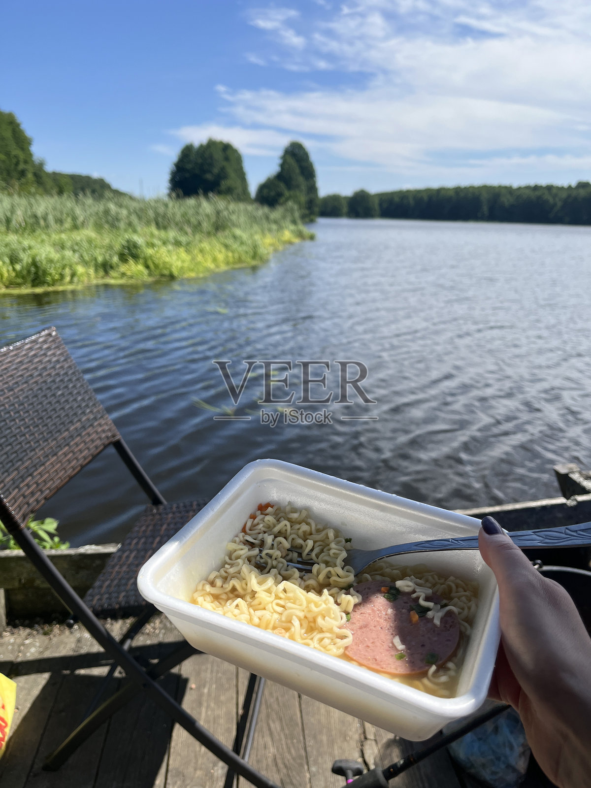 湖边塑料碗里的方便面,户外露营午餐照片摄影图片
