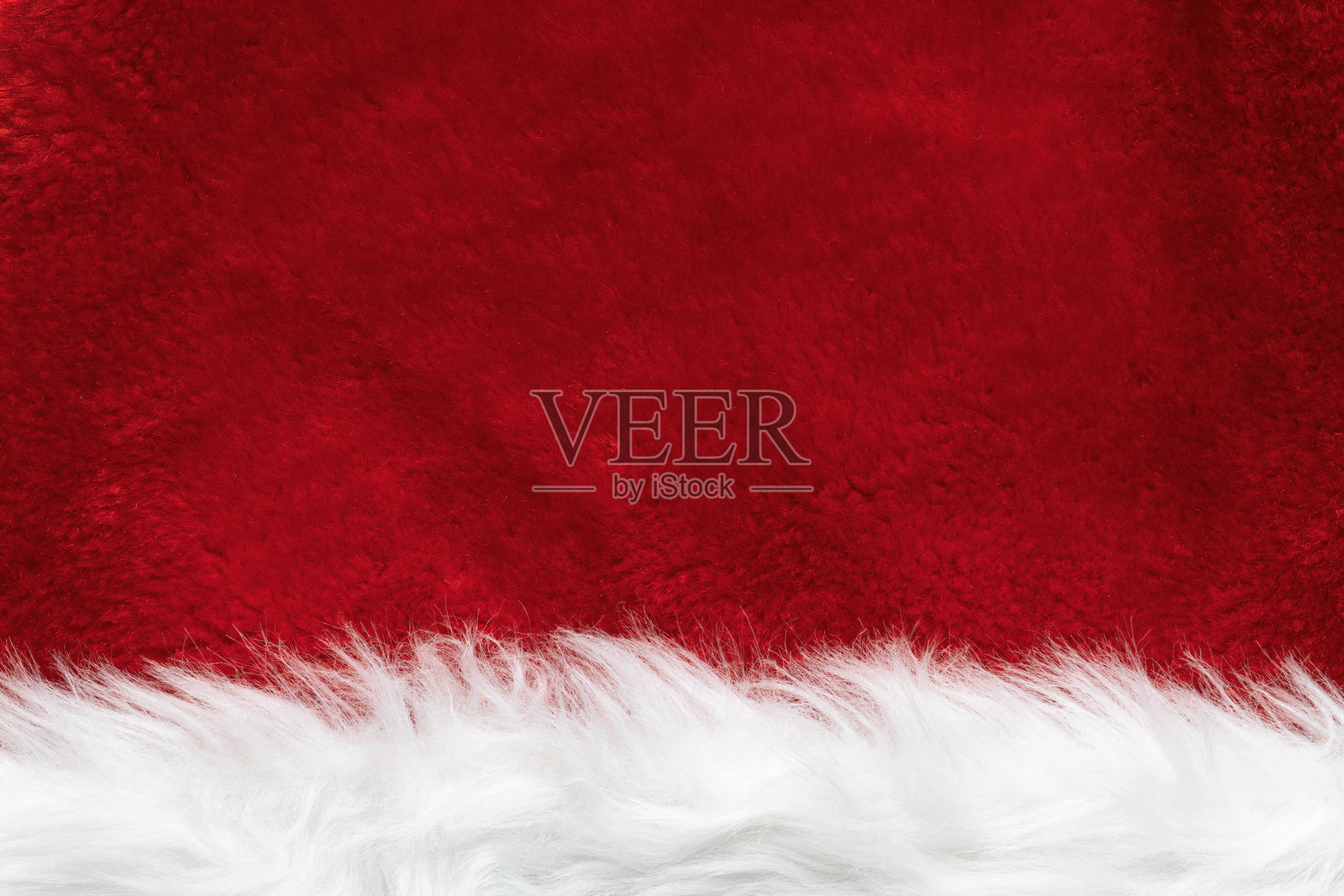 圣诞老人帽子人造毛绒纹理的特写。红色和白色的圣诞背景。照片摄影图片