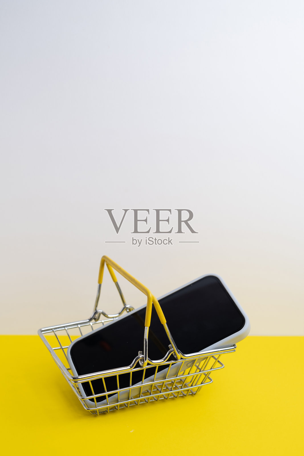 移动电子商务。购物篮里的智能手机照片摄影图片