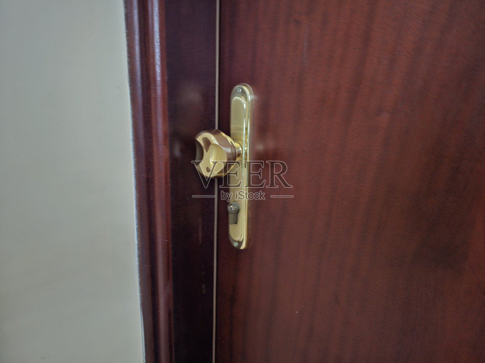 带有独特锁设计的金色把手门,木框捕捉照片摄影图片