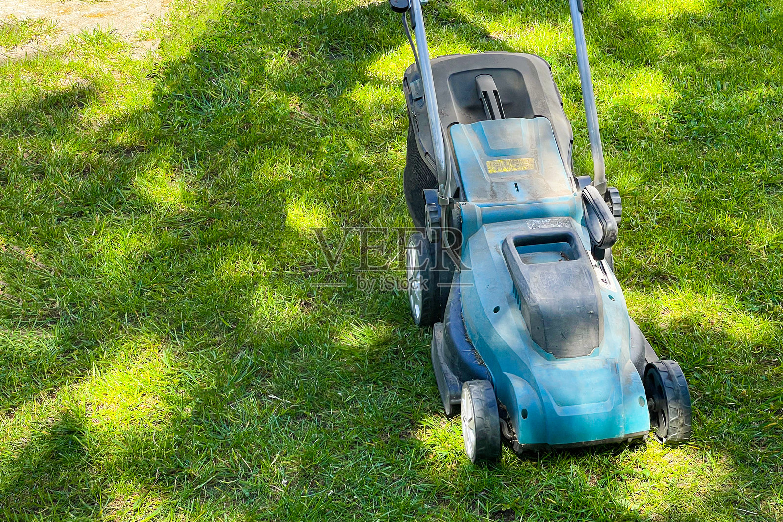 电动割草机,修剪花园草坪。照片摄影图片