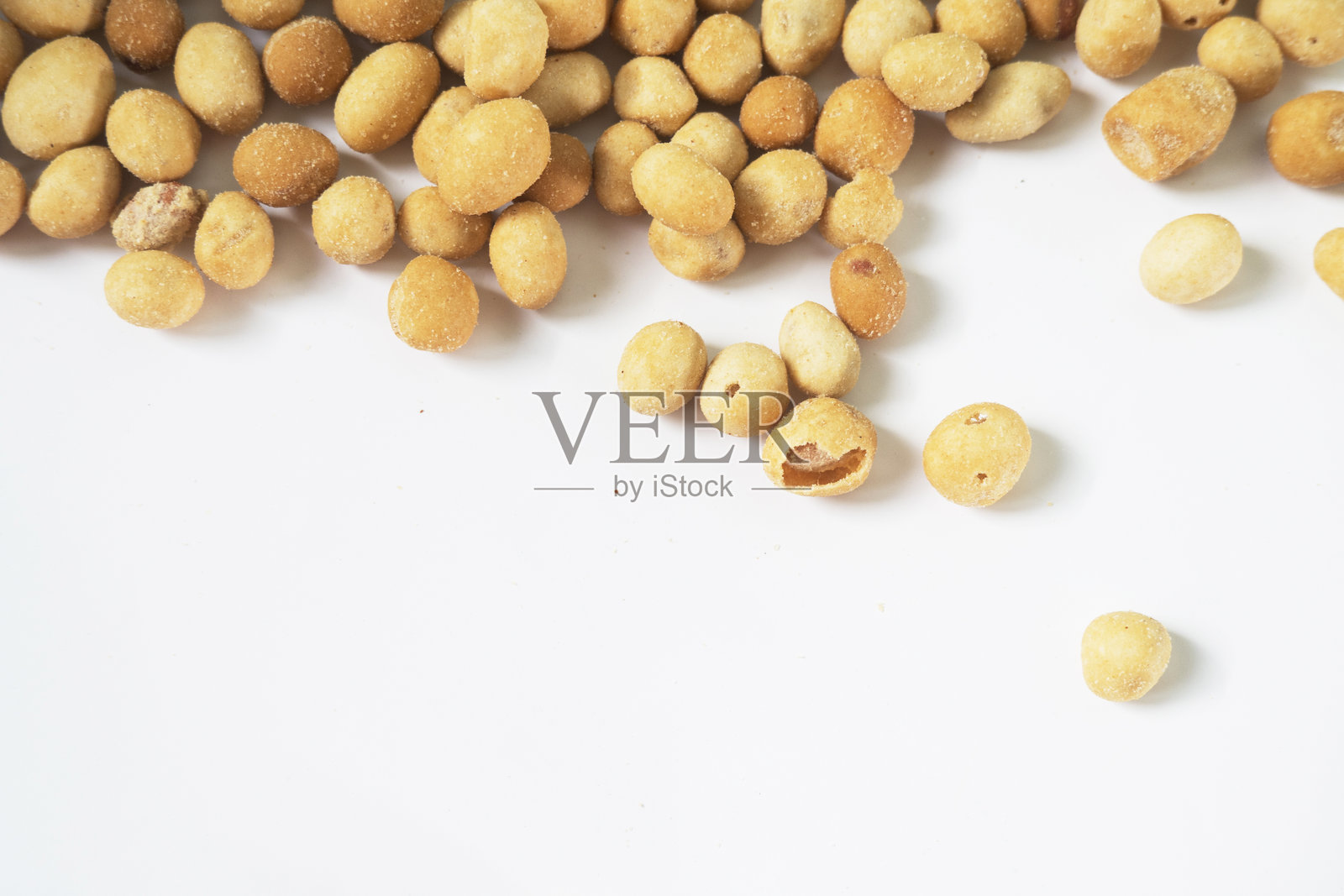 散落在白色背景上的裹粉花生零食照片摄影图片