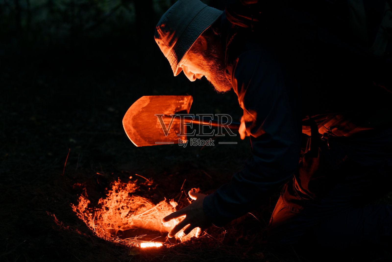 一个人正用铲子在泥土里挖掘照片摄影图片