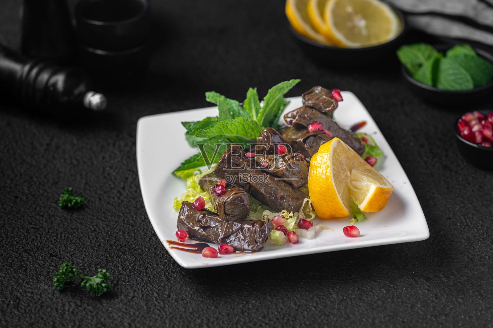 酿葡萄叶,佐以柠檬和石榴。照片摄影图片