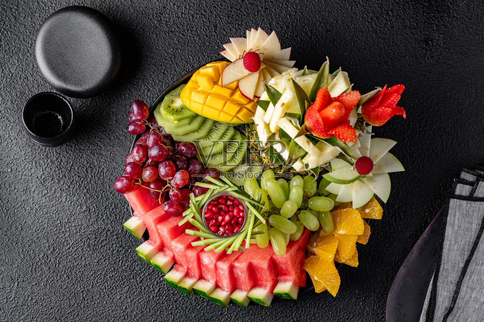 黑色背景上的彩色水果拼盘。照片摄影图片