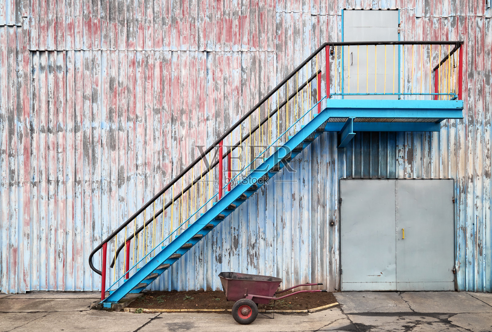 旧工业建筑的墙壁,带有楼梯和手推车照片摄影图片