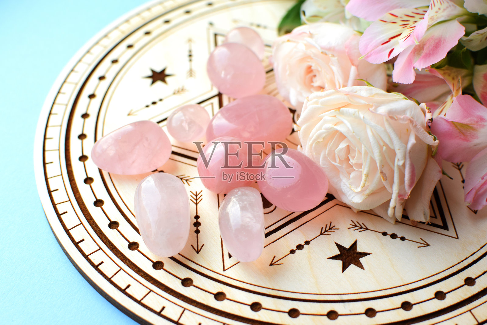 用于占卜的木质祭坛上的蔷薇石英晶体和粉色玫瑰。疗愈水晶。占卜、巫术、精神玄学实践。照片摄影图片