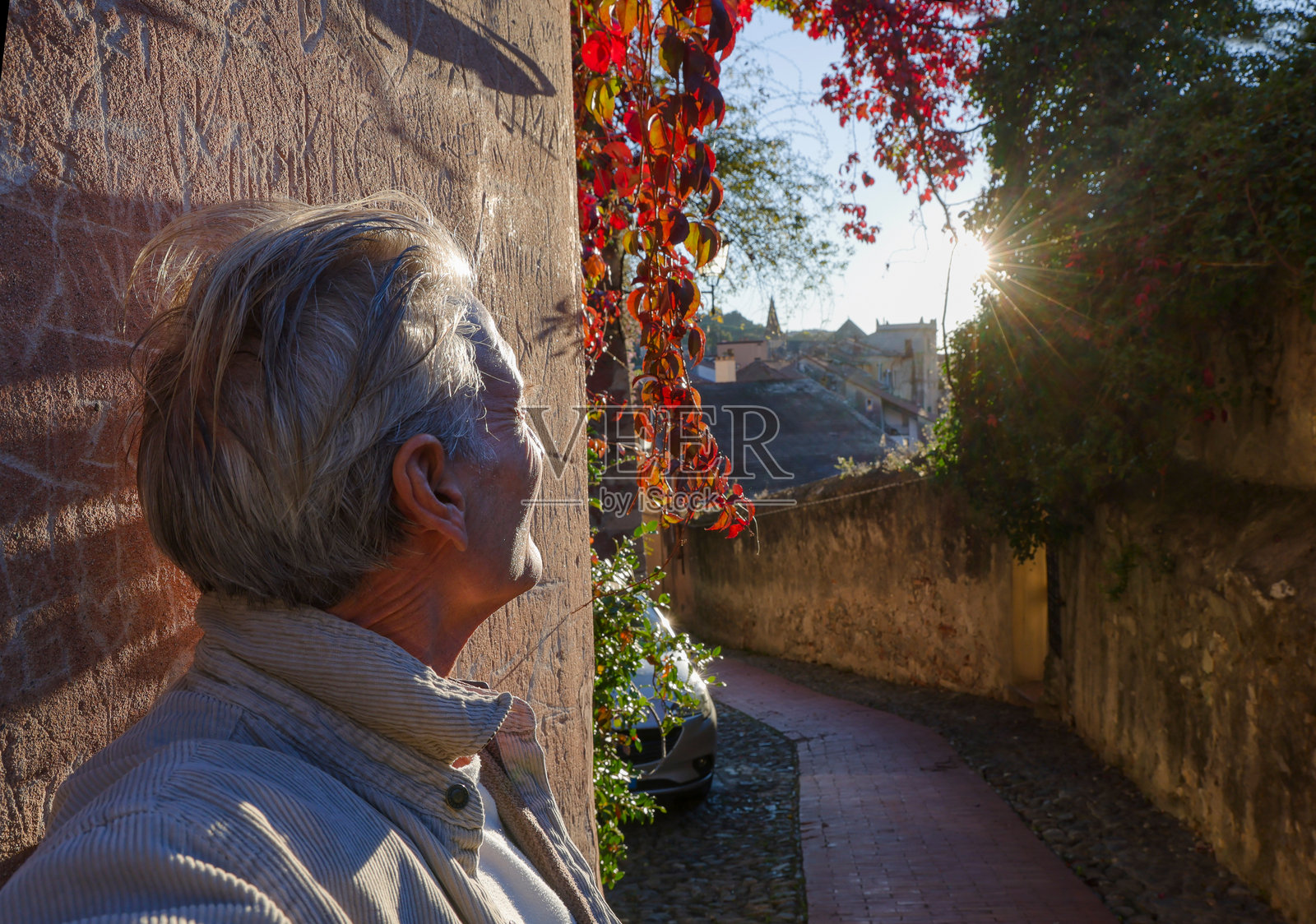 日出时分,一位成熟男子在古老村庄的个人资料视图,意大利利古里亚照片摄影图片