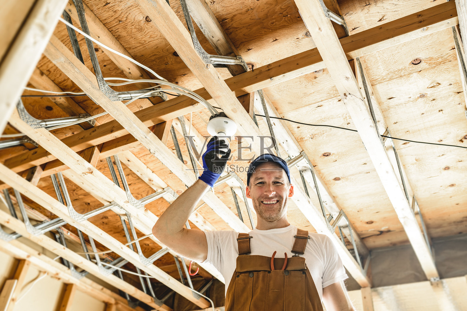电工在地下室修理灯泡照片摄影图片