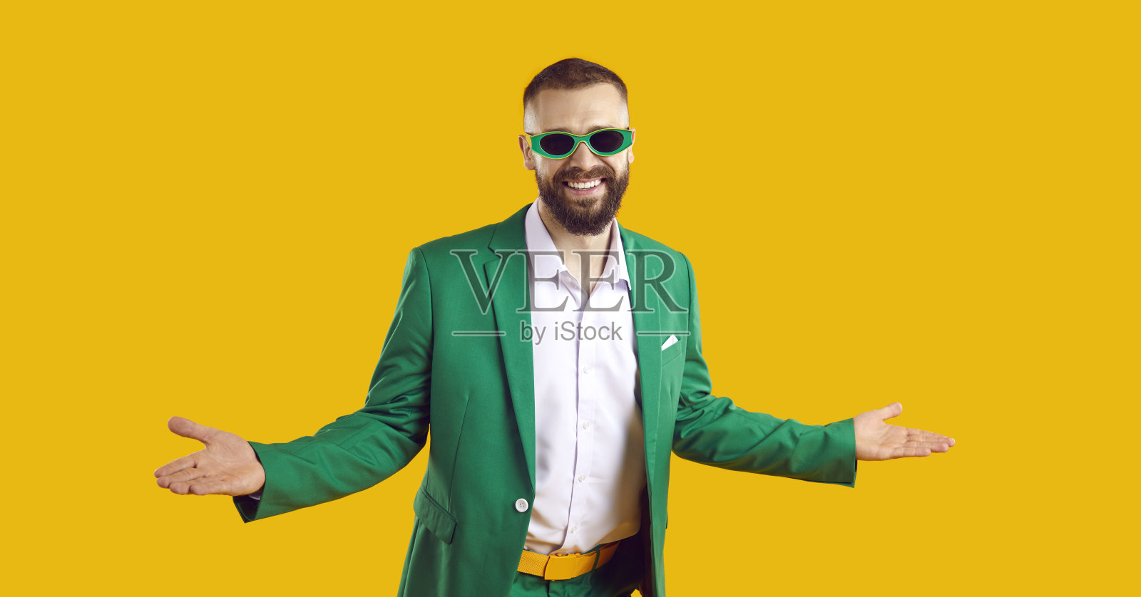 穿着绿色西装、戴着太阳镜的搞笑快乐男人,欢迎您参加圣帕特里克节派对照片摄影图片