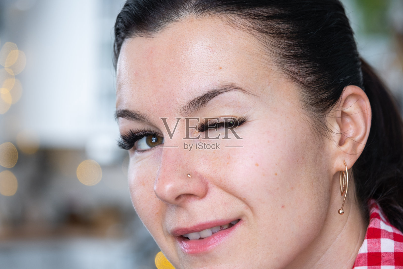 特写镜头中,一位女士拥有长长的假睫毛,上面点缀着水钻。为节日做准备。照片摄影图片