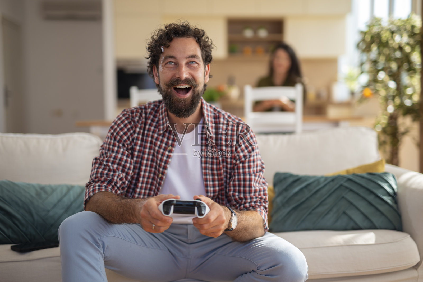 快乐的男人在家里的沙发上玩电子游戏照片摄影图片