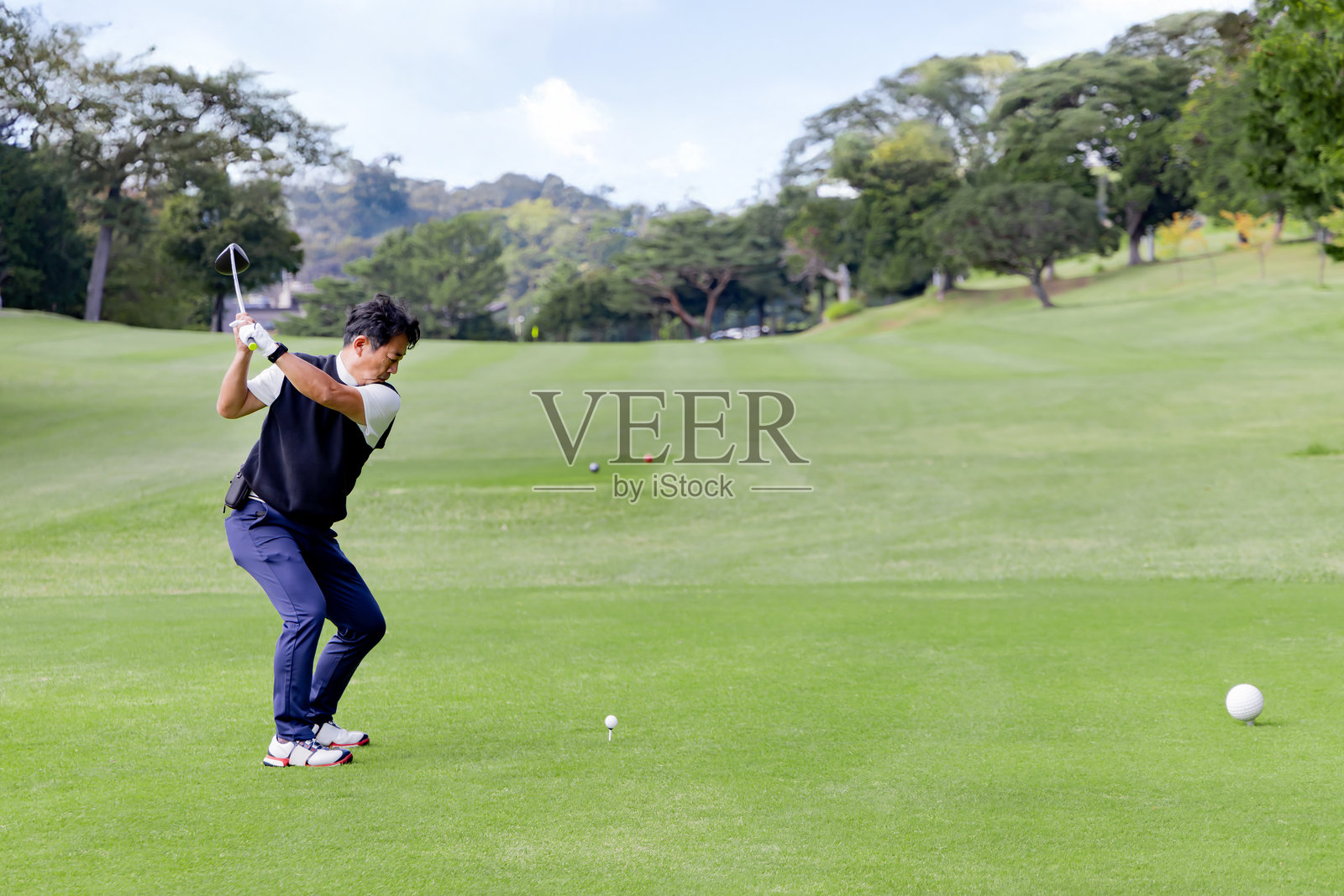 一位中年日本男子正在打高尔夫球照片摄影图片
