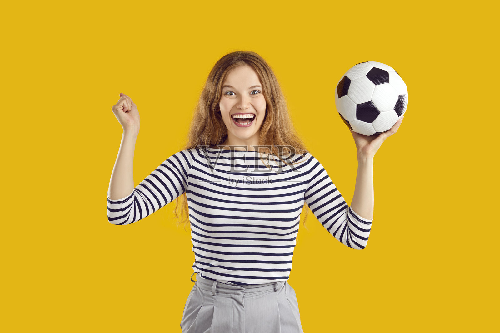 一名年轻女子在足球比赛中庆祝球队胜利,她看起来开心、有趣、兴奋照片摄影图片