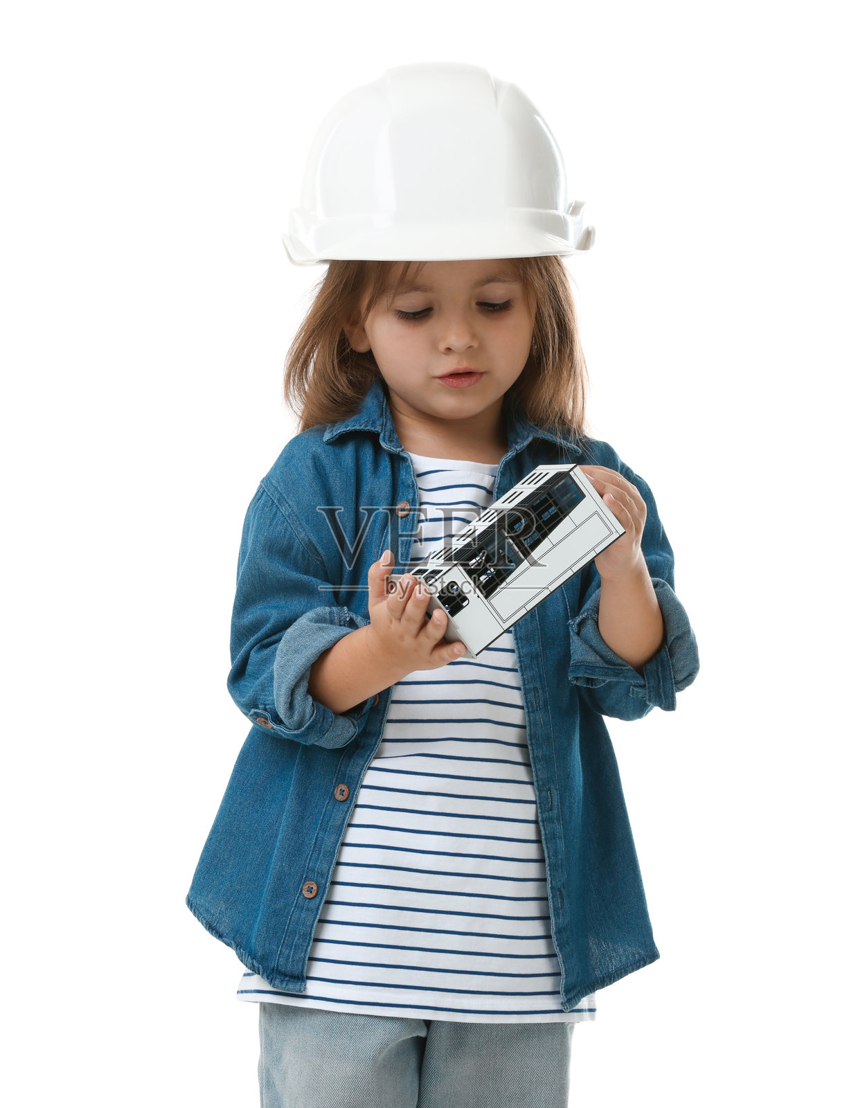职业选择。戴着安全帽的小女孩拿着建筑模型,在白色背景前假装自己是建筑师照片摄影图片