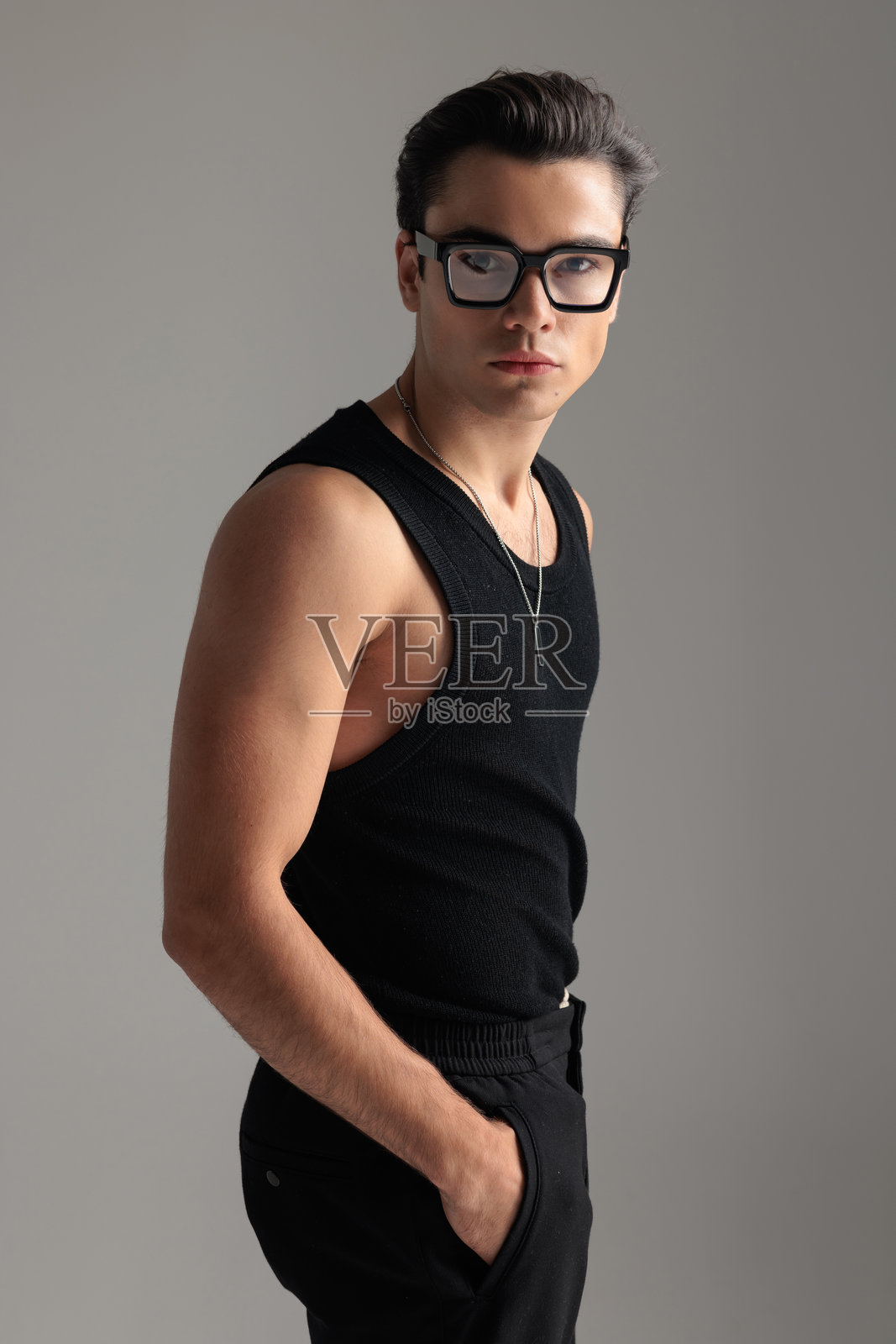 侧面看,一个戴眼镜的酷炫休闲男子双手插在口袋里照片摄影图片