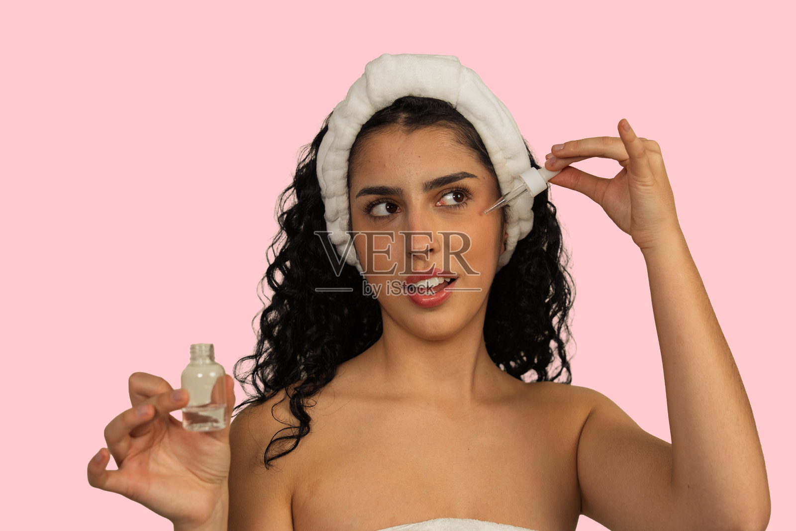 女性在护肤流程中将精华液涂抹于面部照片摄影图片