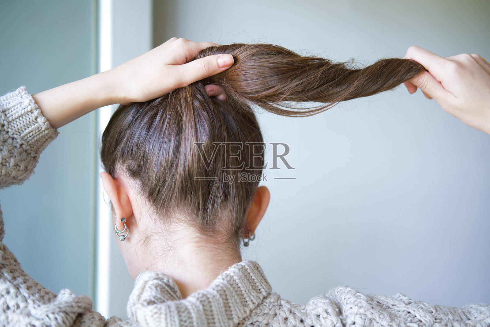 年轻女子抓着她分叉的发梢。照片摄影图片