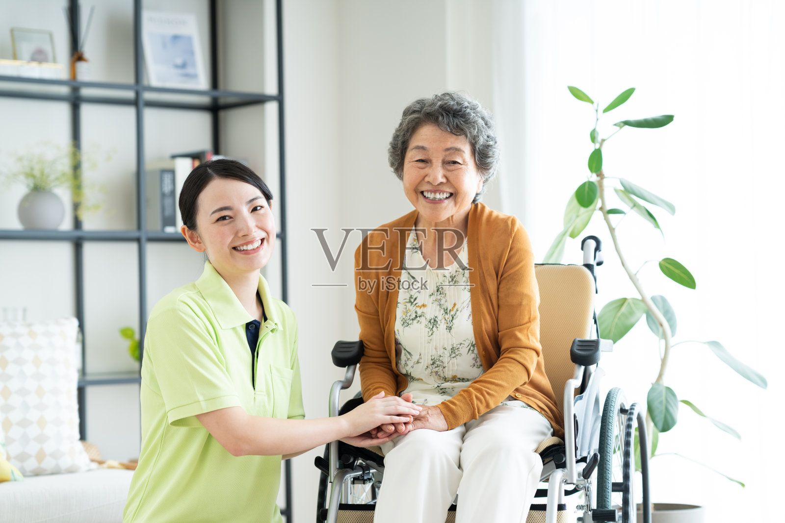 坐轮椅的老年女性和年轻女性护理员照片摄影图片