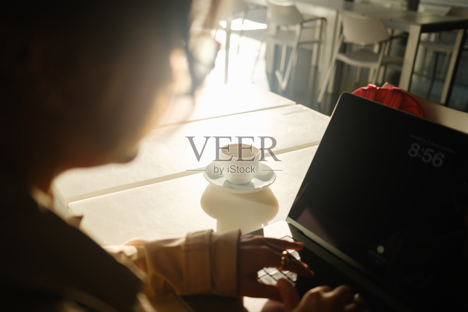 女人在咖啡馆用笔记本电脑工作,旁边放着一杯咖啡照片摄影图片