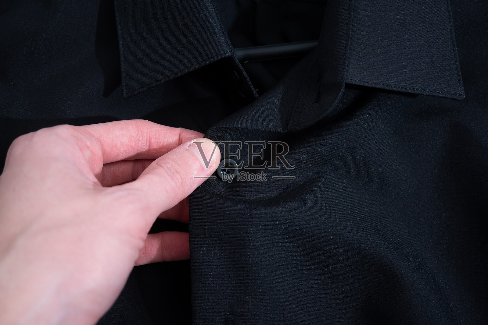 黑色衬衫挂在衣架上照片摄影图片