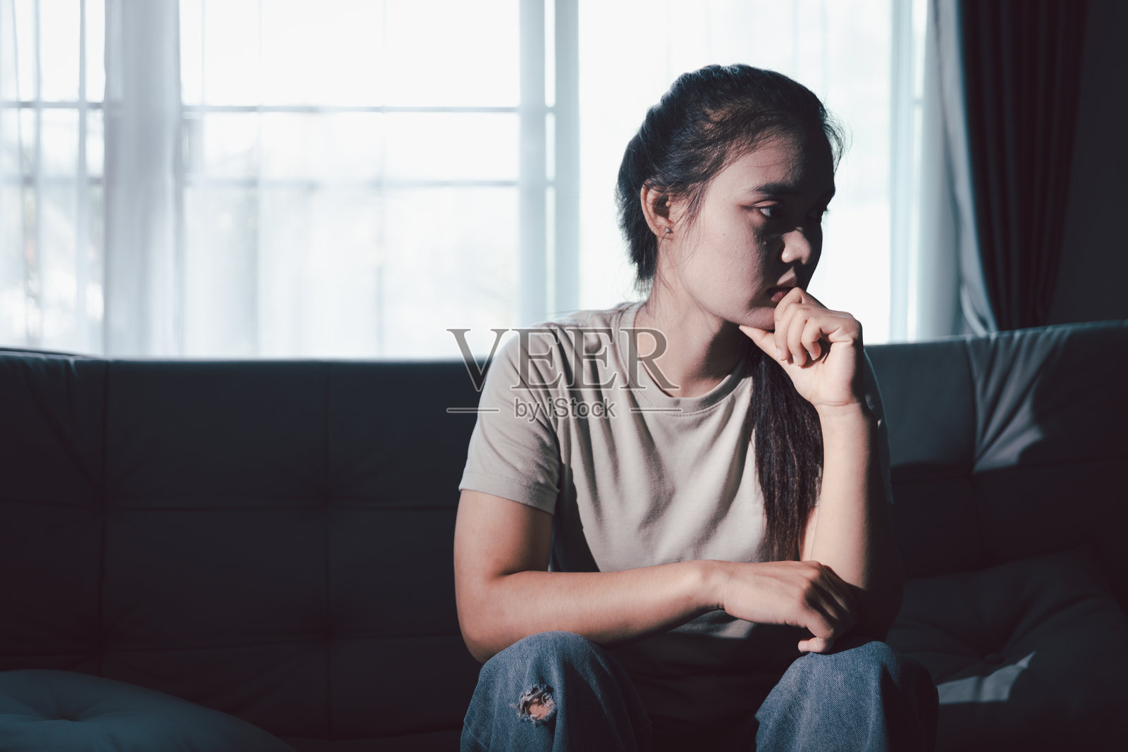 悲伤的女人独自坐着,情绪激动,她悲伤不开心的表情透露出深深的绝望,压力和痛苦让她感到沮丧。悲伤,绝望,孤独,沮丧,压力照片摄影图片