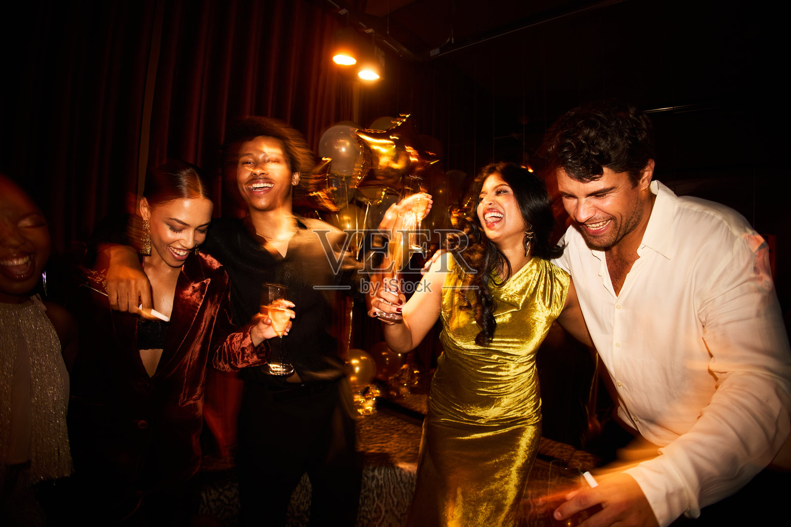 一群欢笑的朋友在迷人的新年庆祝活动中一起跳舞,玩得很开心照片摄影图片