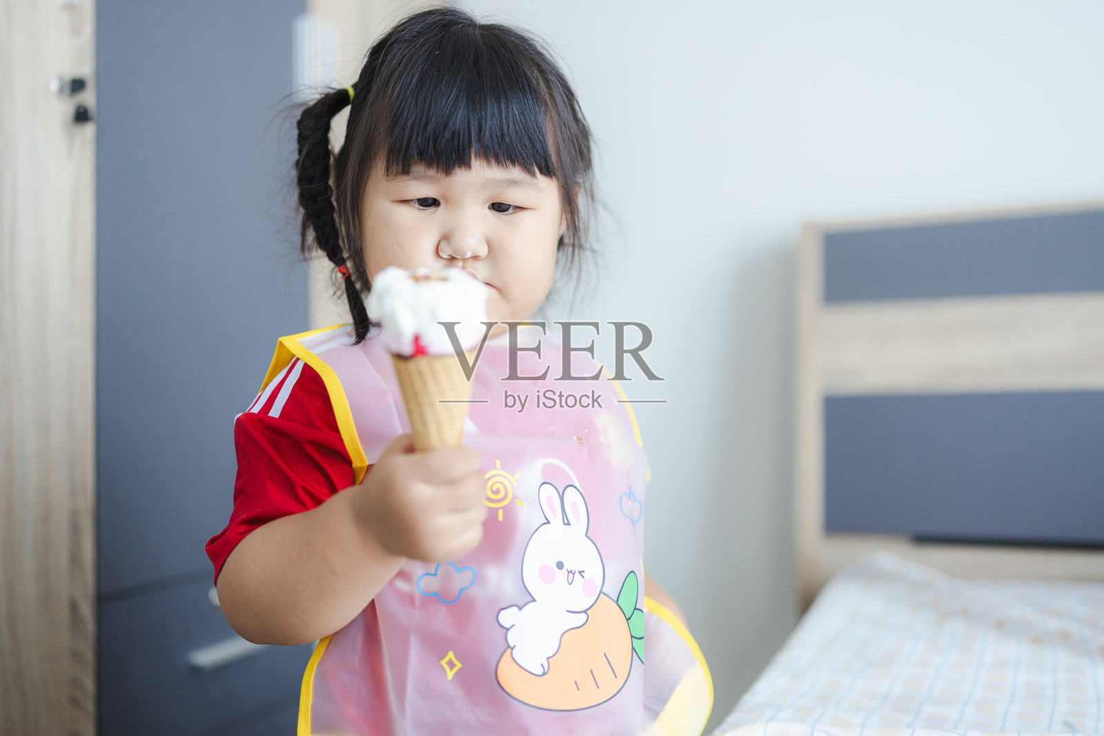 可爱的亚洲小女孩在咖啡馆吃冰淇淋的肖像。照片摄影图片