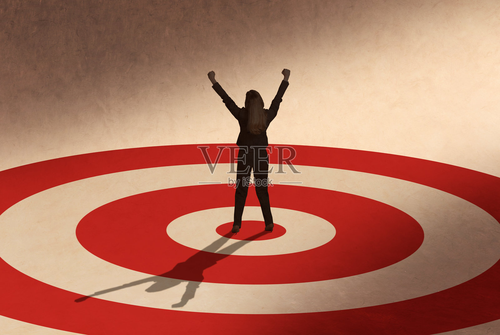 女子站在靶心中央,高举双手欢呼照片摄影图片
