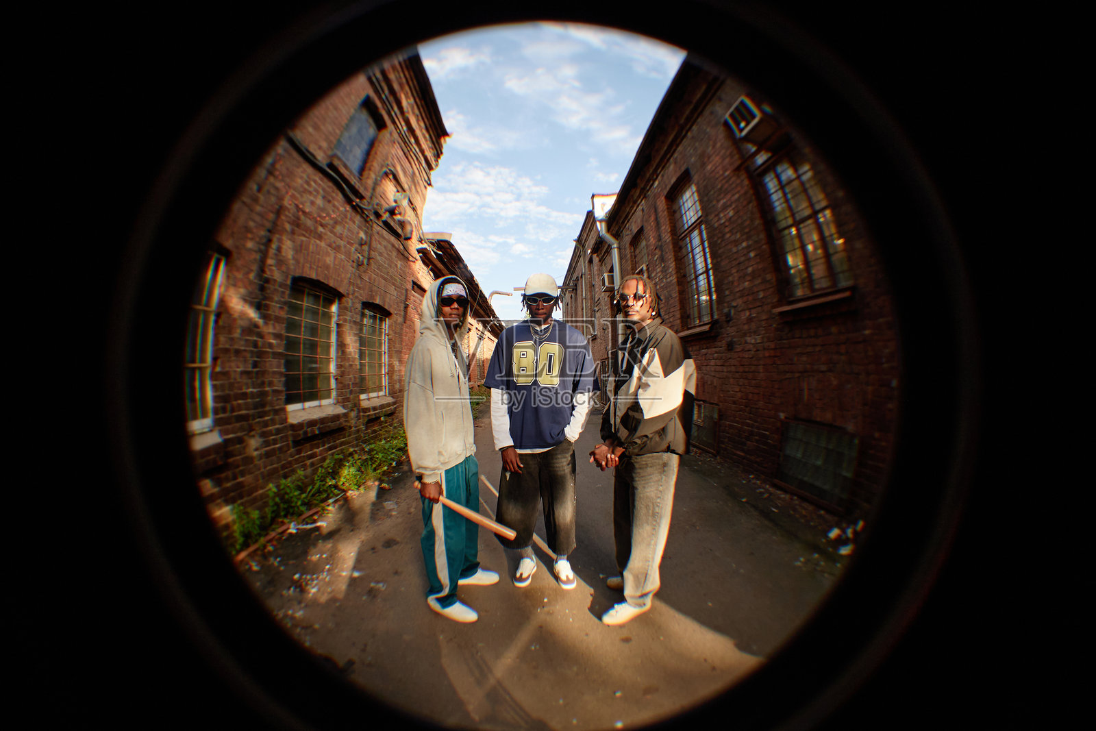 三个年轻的黑人男性,站在古老的砖砌建筑之间照片摄影图片