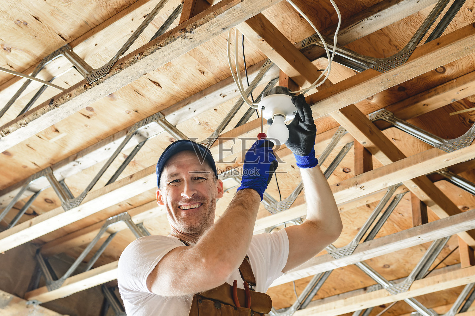 一名电工在地下室修理灯泡照片摄影图片
