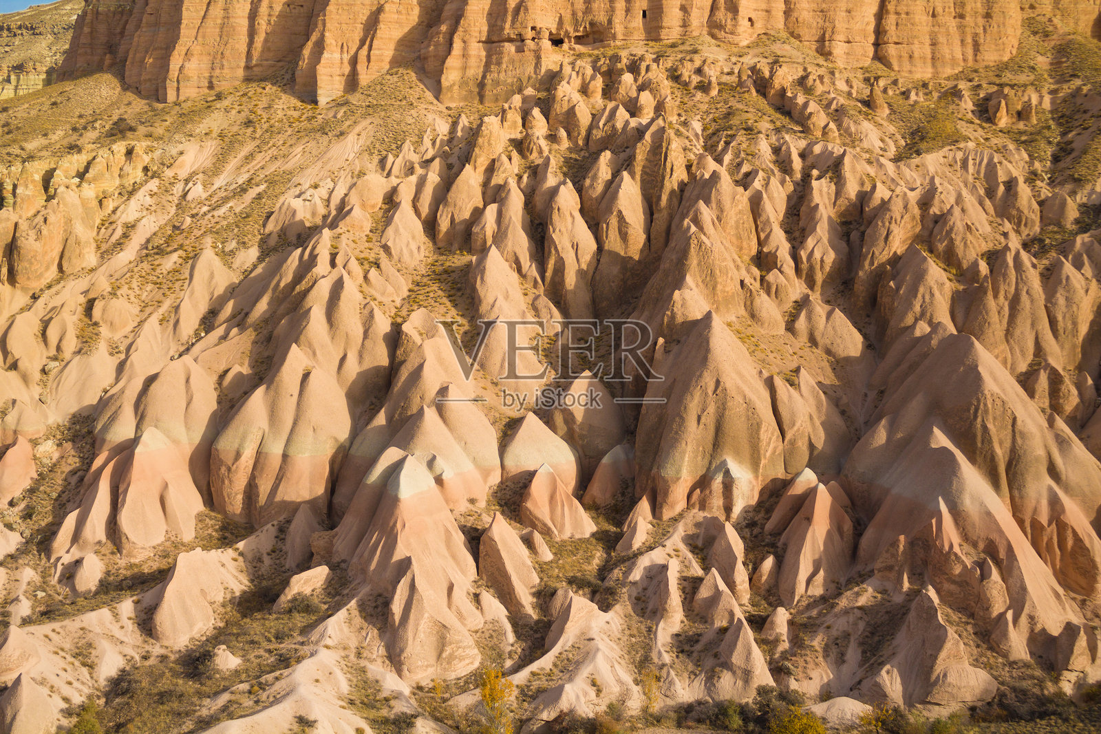 土耳其卡帕多奇亚的岩石构造,在晴朗的日光下,展示了高耸的砂岩烟囱、纹理分明的悬崖和自然侵蚀形成的形状照片摄影图片