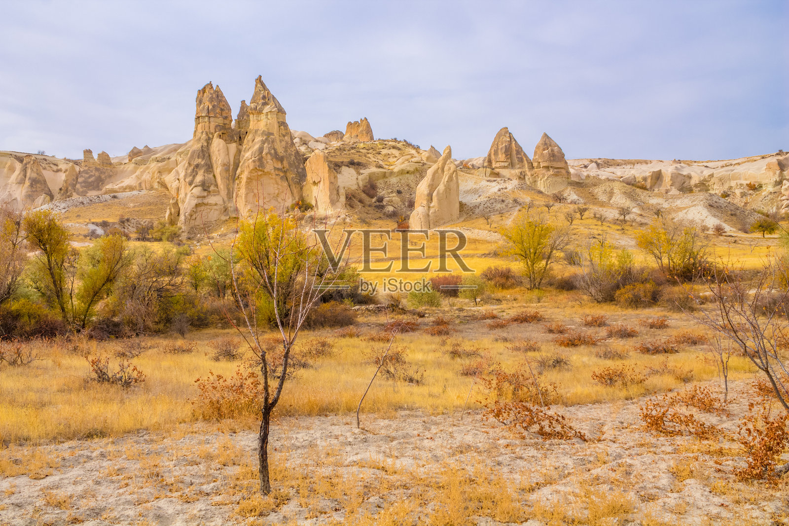 土耳其卡帕多奇亚的岩石构造,在晴朗的日光下,展示着高耸的砂岩烟囱、纹理清晰的悬崖和自然侵蚀形成的形状照片摄影图片