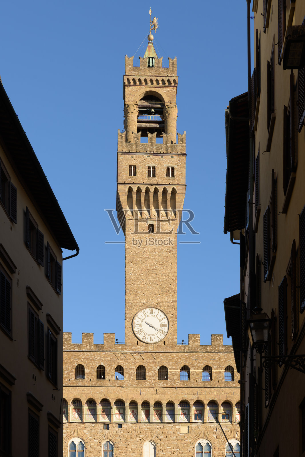 意大利佛罗伦萨,阿尔诺尔福塔矗立在屋顶之上,是旧宫不可错过的地标,狭窄的中世纪街道勾勒出其轮廓。照片摄影图片