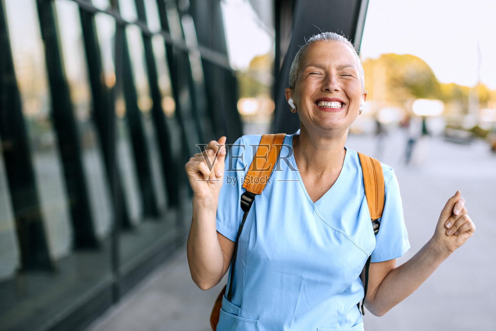 快乐的女护士在户外听音乐照片摄影图片