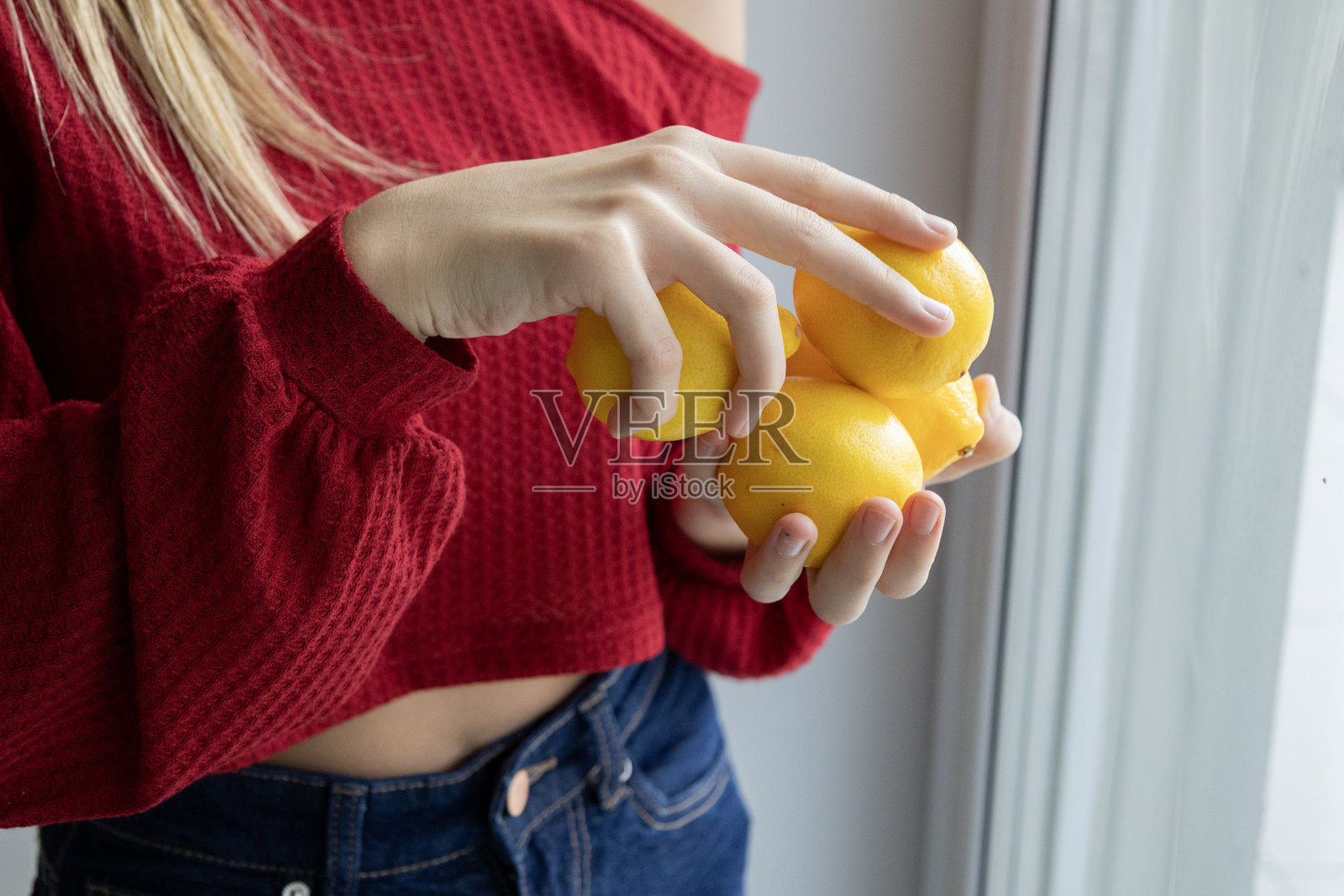年轻女子在浅色背景上手持新鲜柠檬,健康饮食概念照片摄影图片