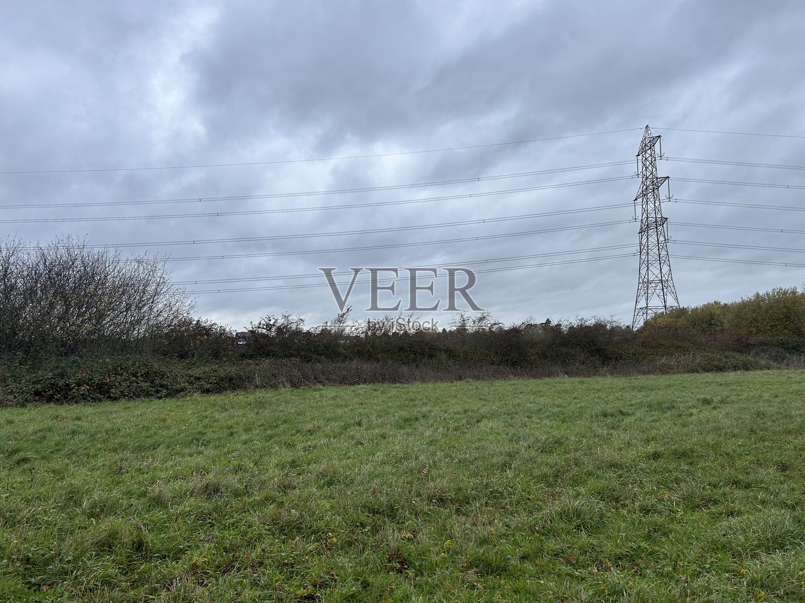 带有输电线路、多云天空和农田地平线的乡村广阔景观照片摄影图片