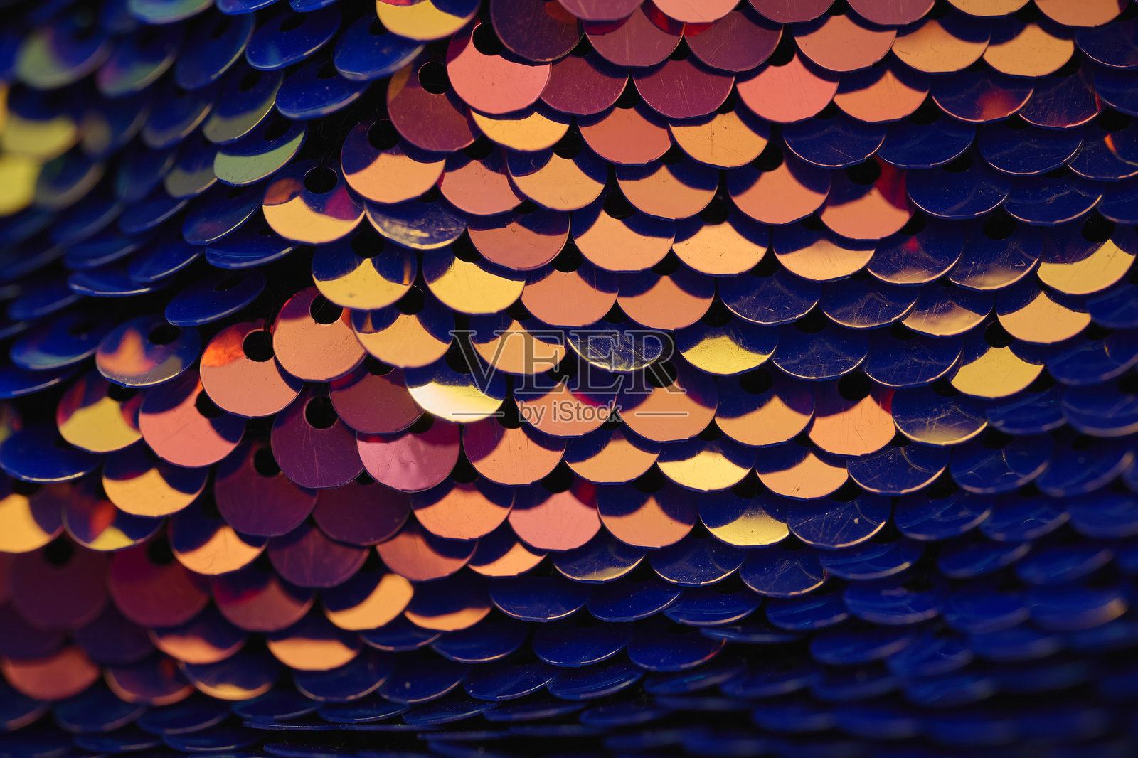 闪亮的亮片在织物上反射出鲜艳的色彩。特写,抽象背景照片摄影图片