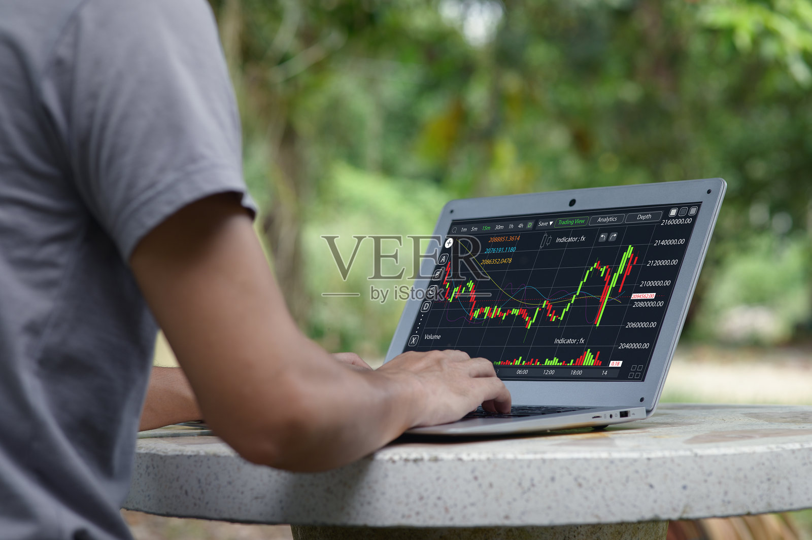 一个人在户外使用笔记本电脑分析股市数据照片摄影图片