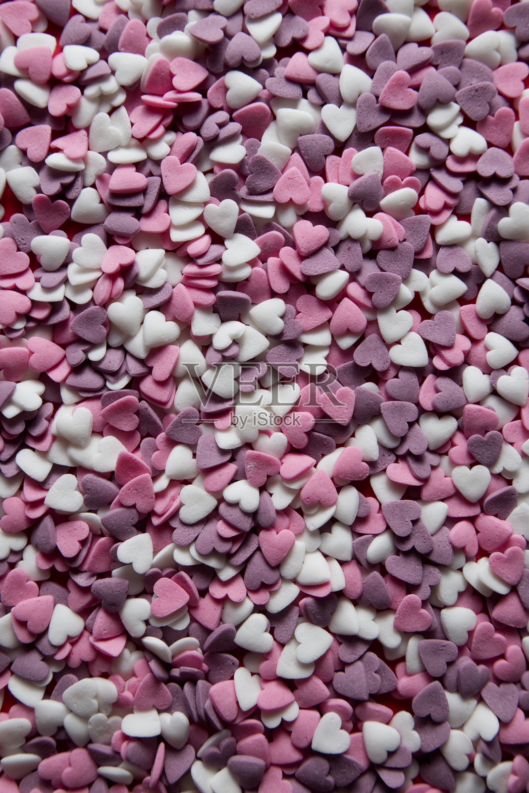 粉色、白色和紫色心形糖珠背景图案照片摄影图片