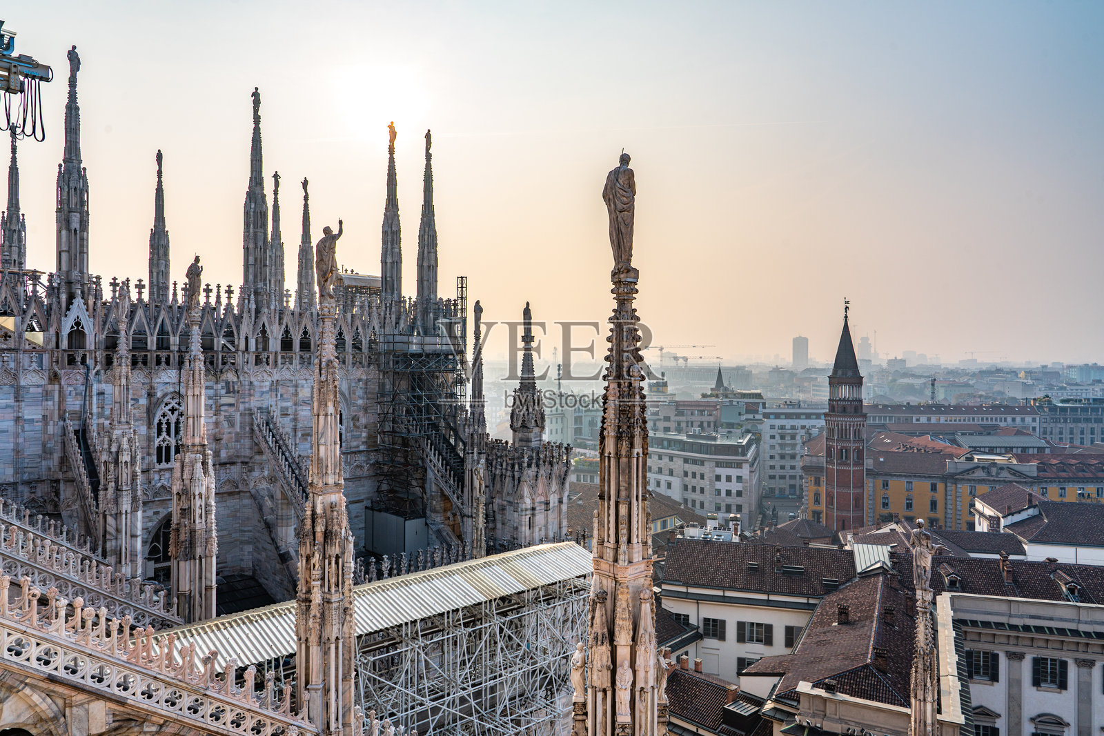 日出时分,意大利米兰大教堂顶部照片摄影图片