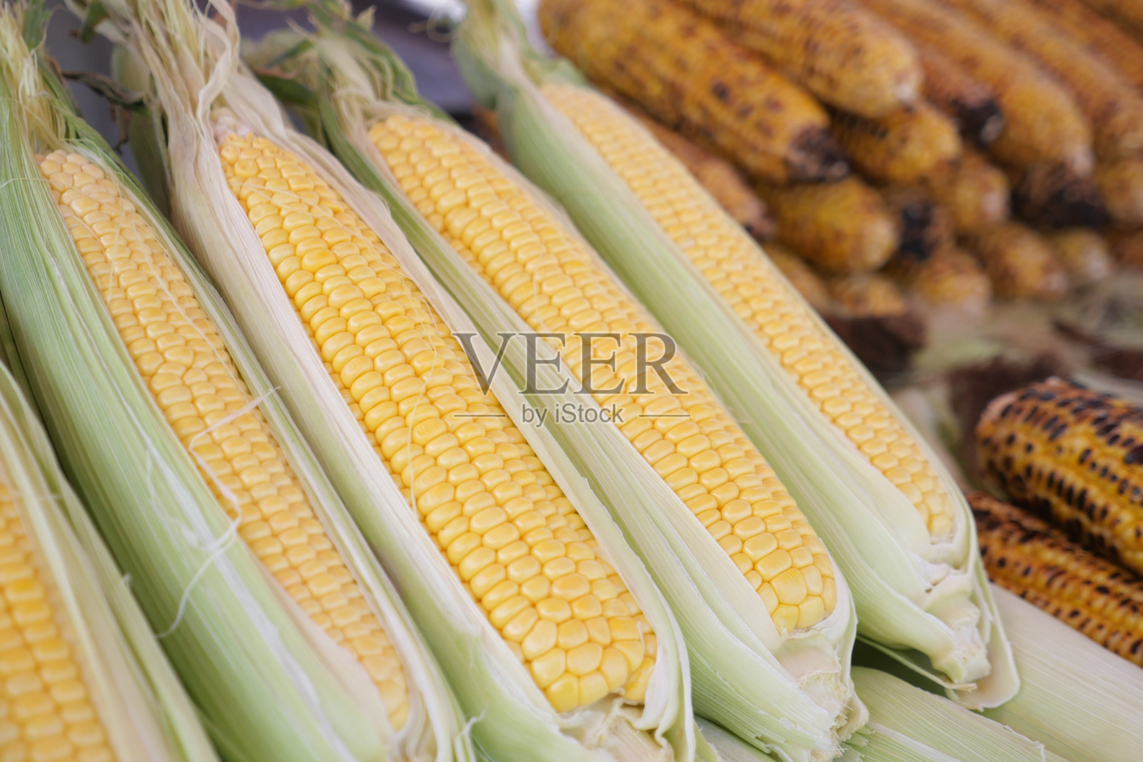 当地集市摊位上展示的新鲜玉米照片摄影图片